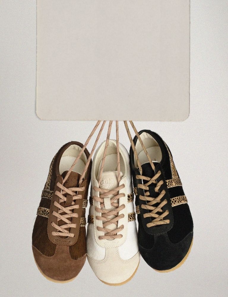 Three pairs of Gola trainers in brown cream and black hanging by their laces