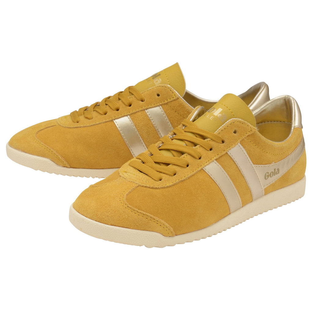 Pair of mustard yellow Gola trainers with gold stripes and accents, angled for full view.