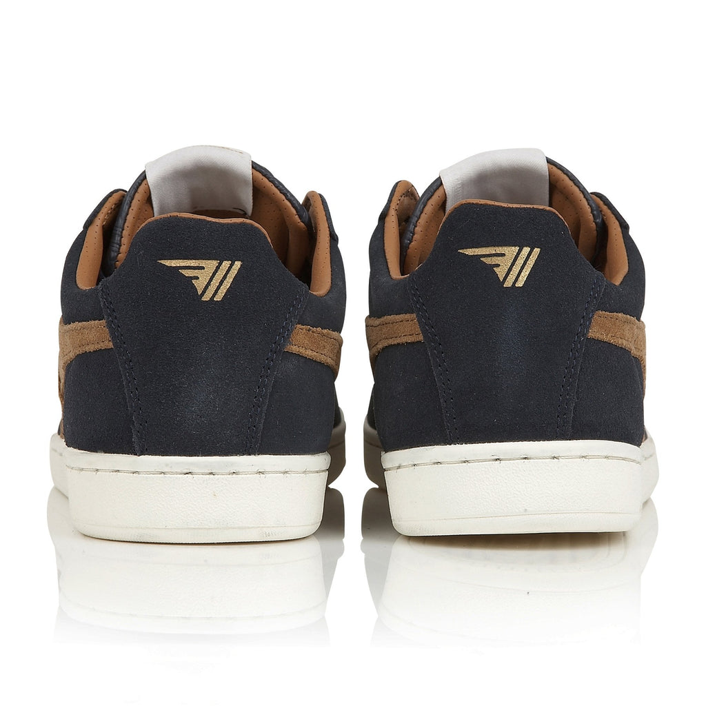 The back view of a pair of men's navy blue suede sneakers with brown accents and white soles.