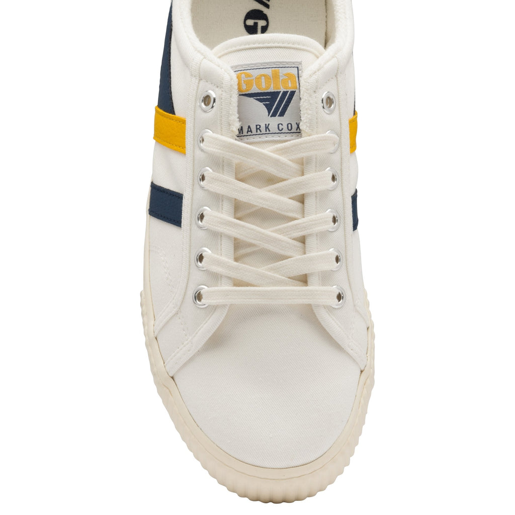A close up of the front of a white Gola sneaker with navy and yellow stripes.