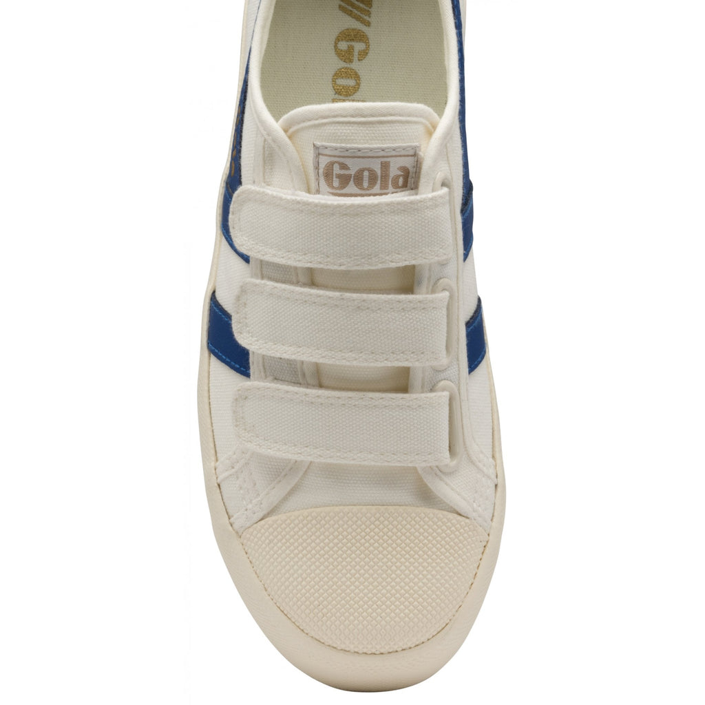 The top-down view of a white Gola sneaker with three Velcro straps and blue stripes.