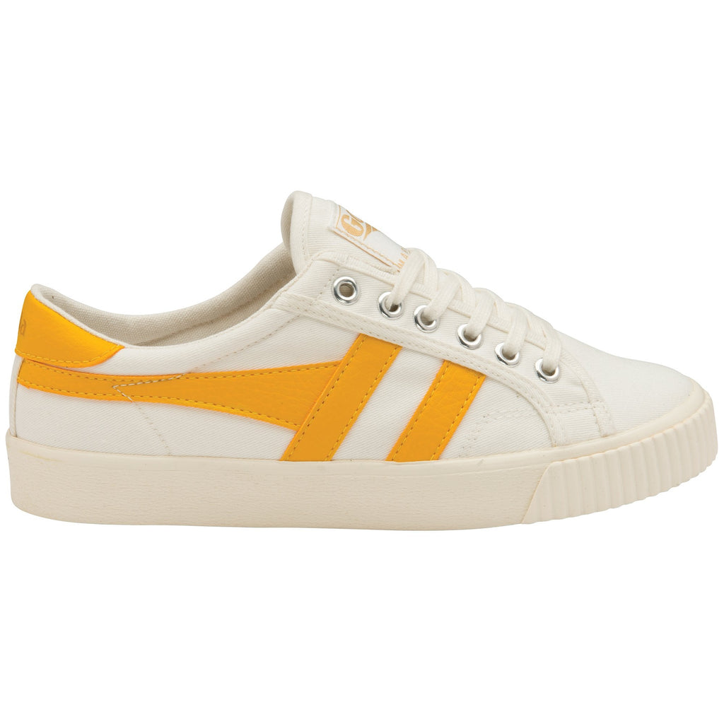A white Gola women's shoe with yellow stripes on the side.