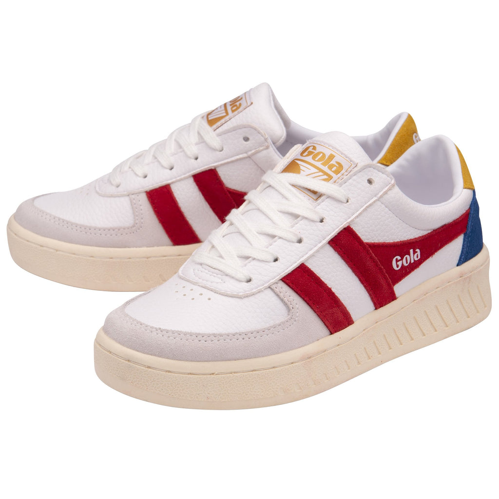 A pair of white trainers with red Gola stripes, blue and yellow accents, shown from an angle.