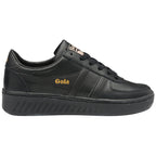 A black Gola trainer with a gold logo on the side and tongue.
