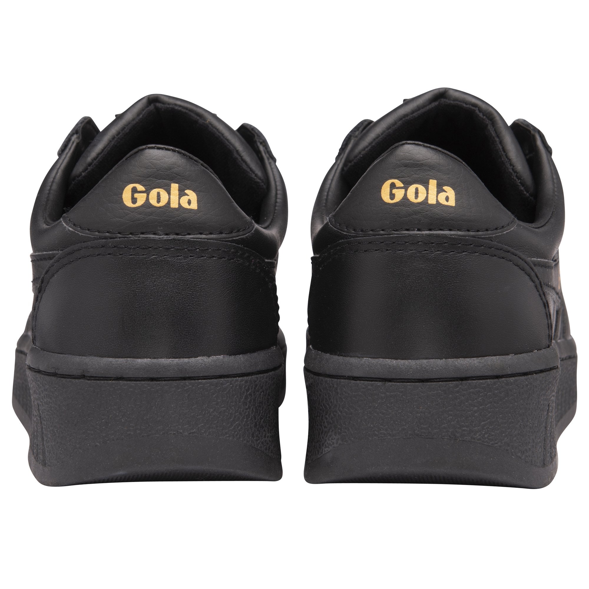 The back of two black Gola trainers, showing gold Gola logo on the heel.