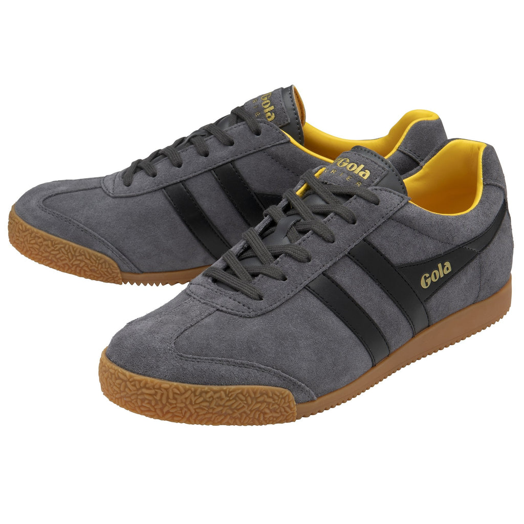 A pair of gray suede Gola sneakers with black stripes and yellow interiors, side view.