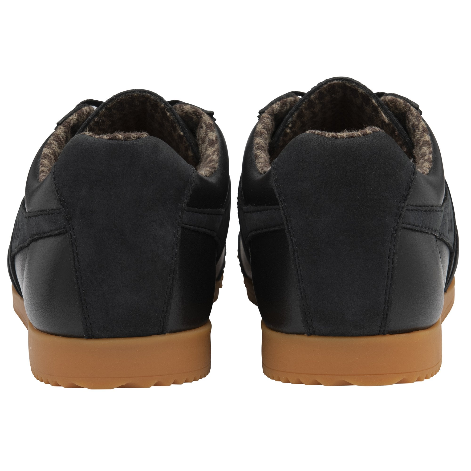 Rear view of two black sneakers with brown soles.