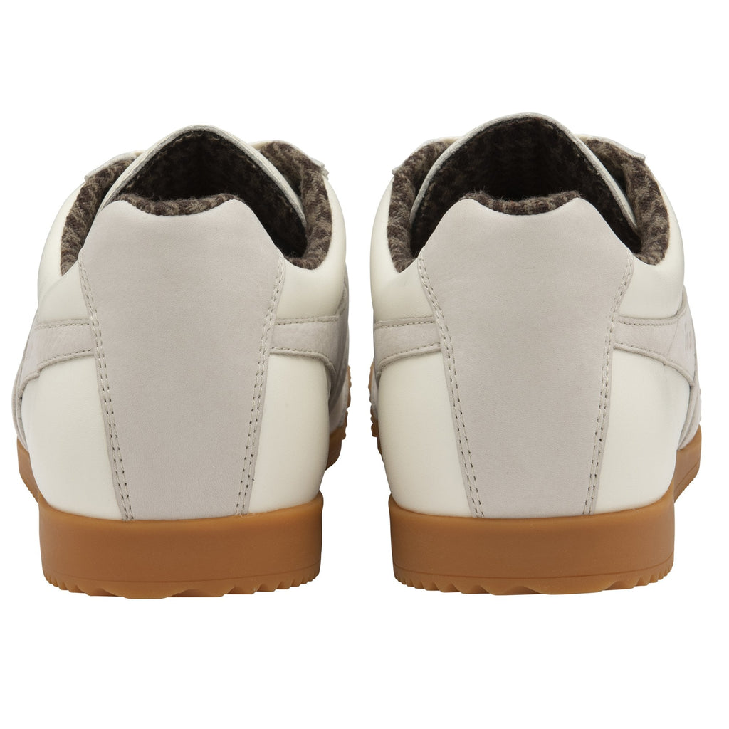 The back view of a pair of off-white sneakers with gum soles.
