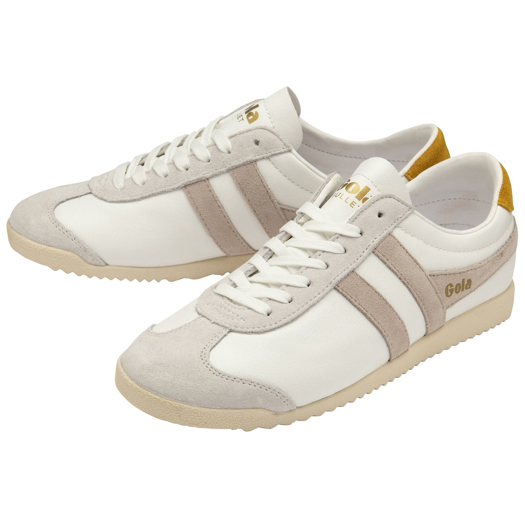 A pair of white and beige Gola Bullet sneakers with gold heel tabs, viewed from an angle.