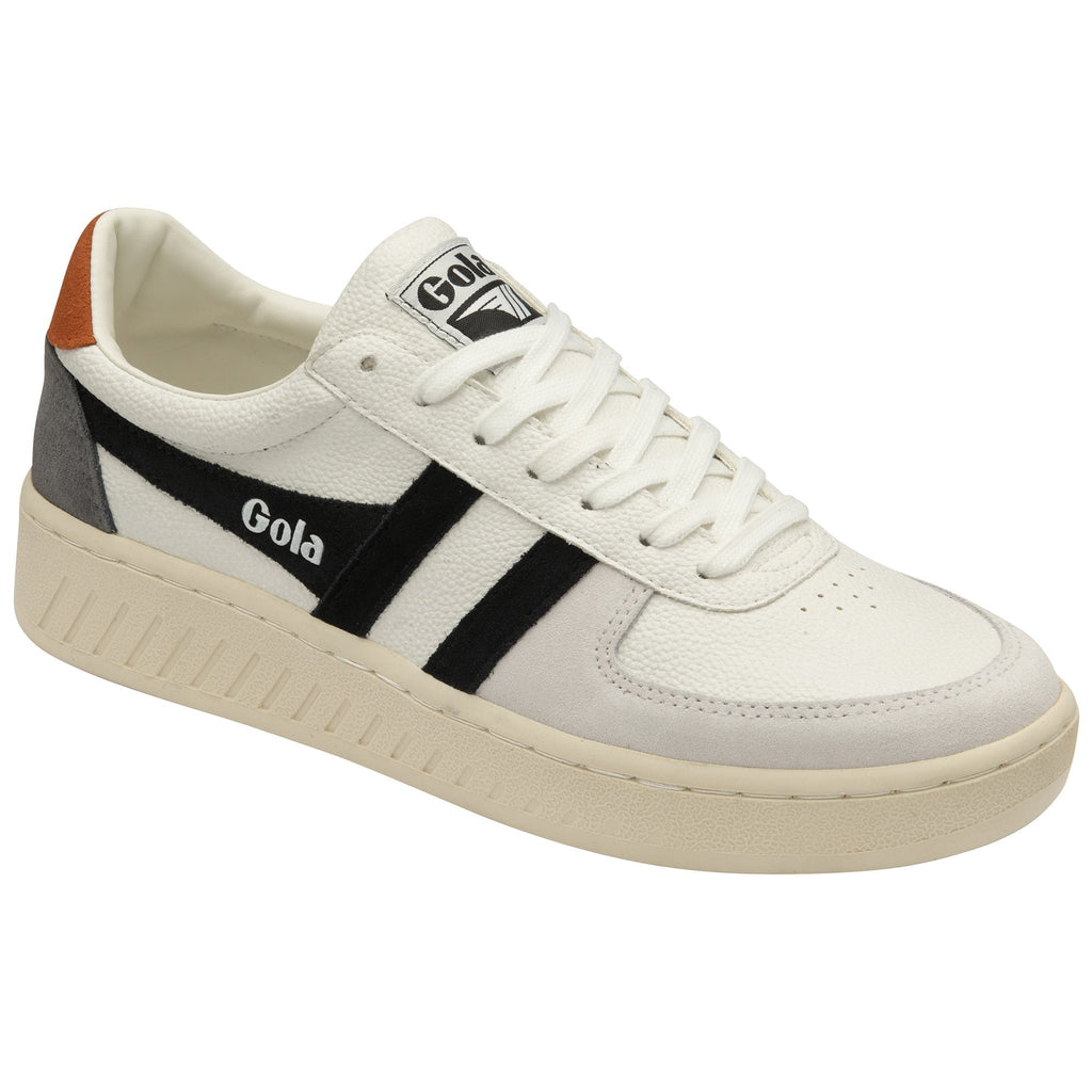 A white Gola sneaker with black stripes and a tan heel tab, shown from a side angle.