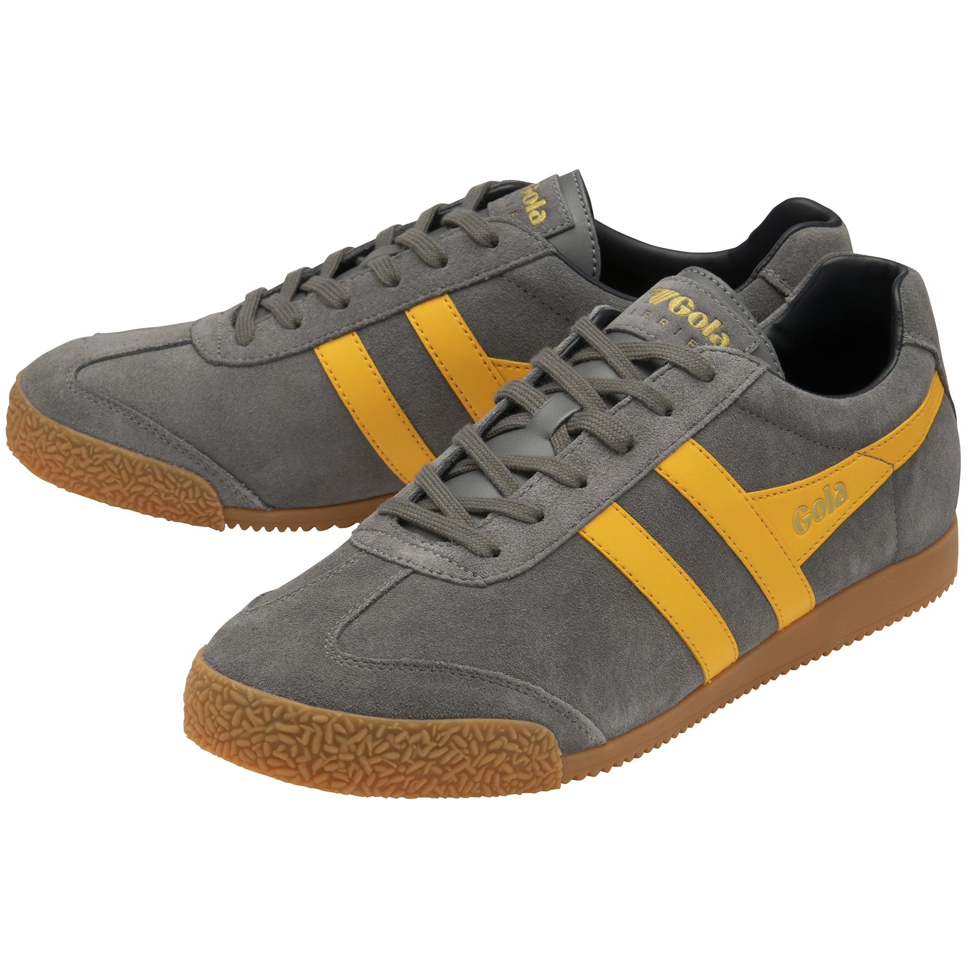 A pair of grey Gola Harrier shoes with yellow stripes.