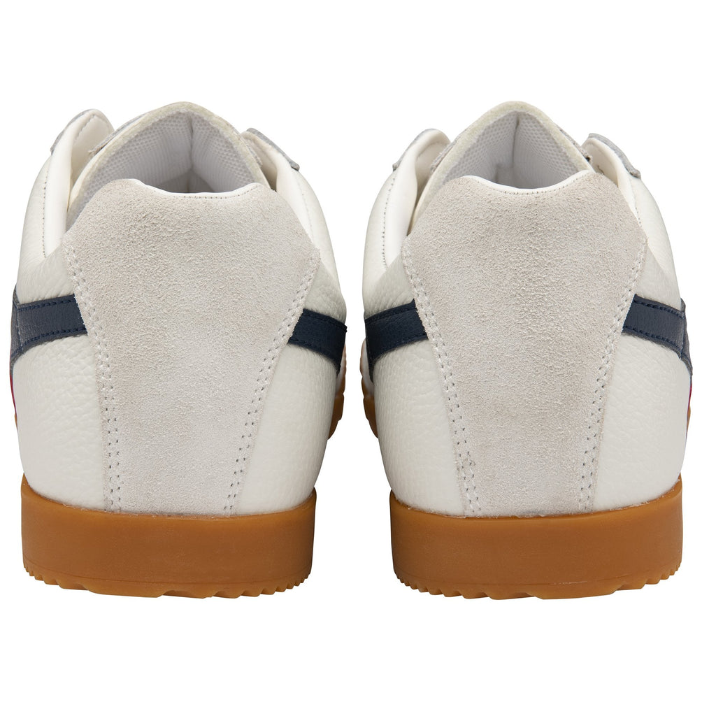 The back view of a pair of white, red, and blue athletic shoes with brown soles.