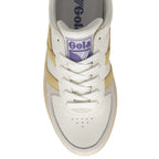 Top view of a Gola sneaker with a white base, gold stripes, and beige sole.