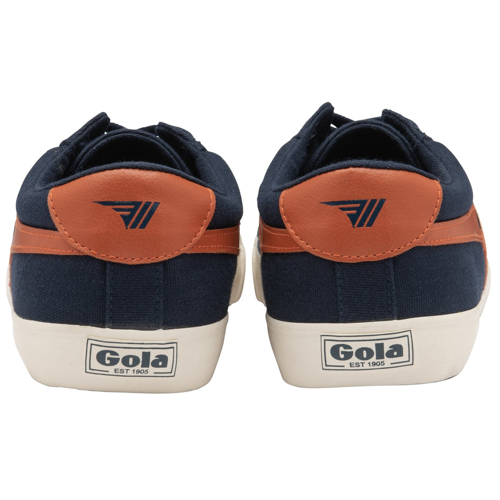 The back view of a pair of Gola low-top navy sneakers with orange accents.