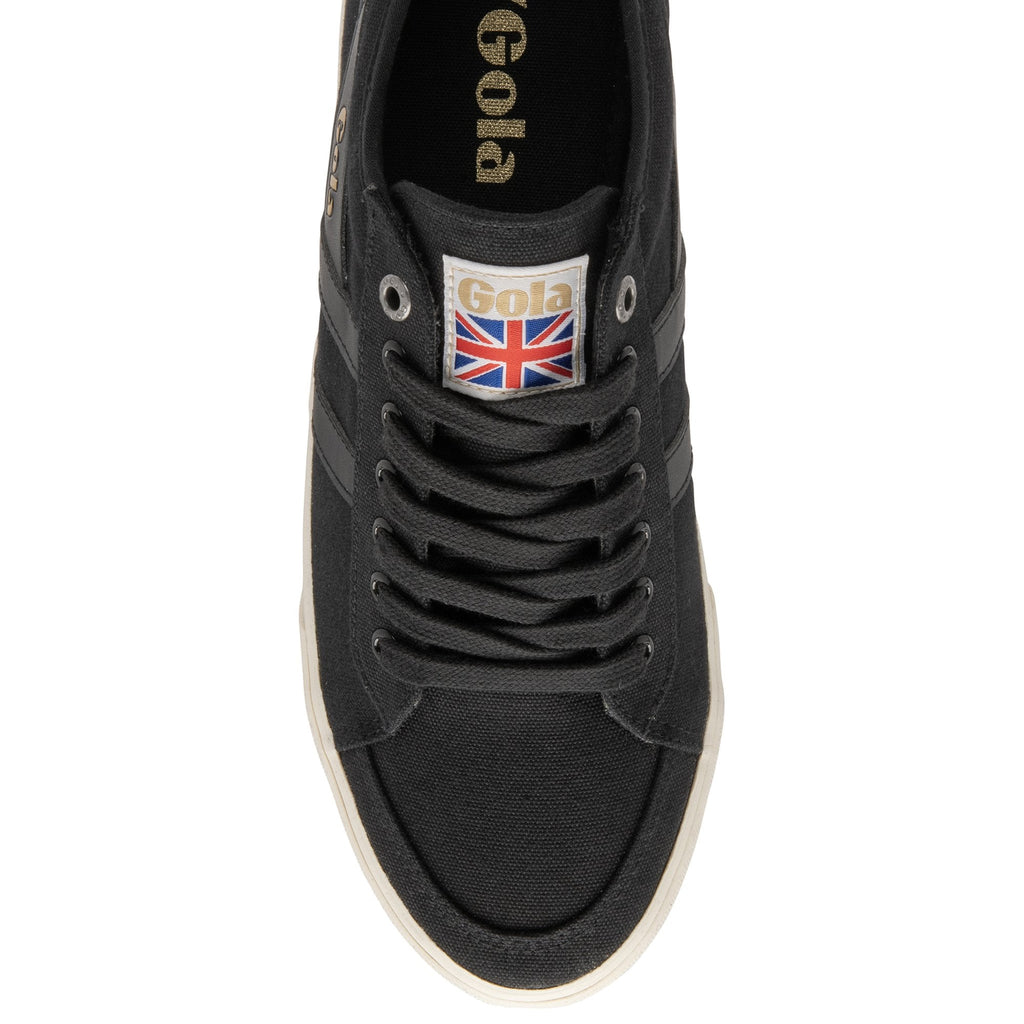 An overhead view of a black canvas Gola sneaker with white soles and a Union Jack tag.