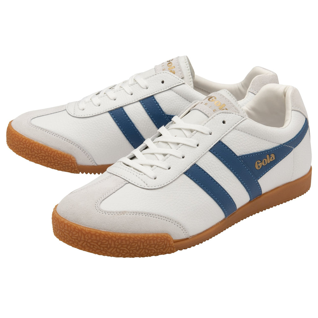 A pair of white Gola Harrier shoes with blue stripes, viewed from an angle.