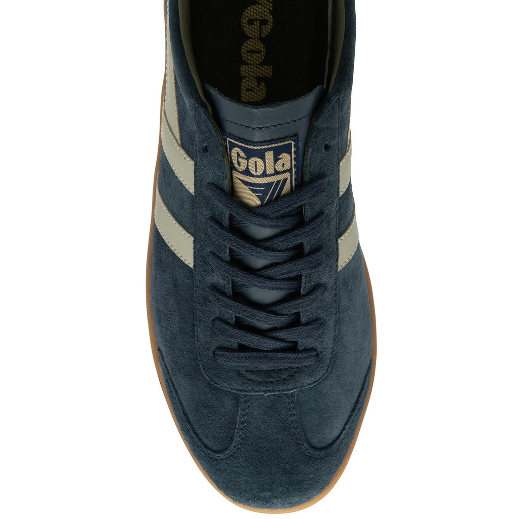 Top down view of a navy suede Gola sneaker with a gum sole and tan accents.