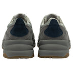 The back view of two light grey and dark grey Gola sneakers with blue accents.
