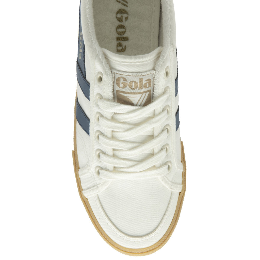A top-down view of a white Gola sneaker with navy stripes and a gum sole.