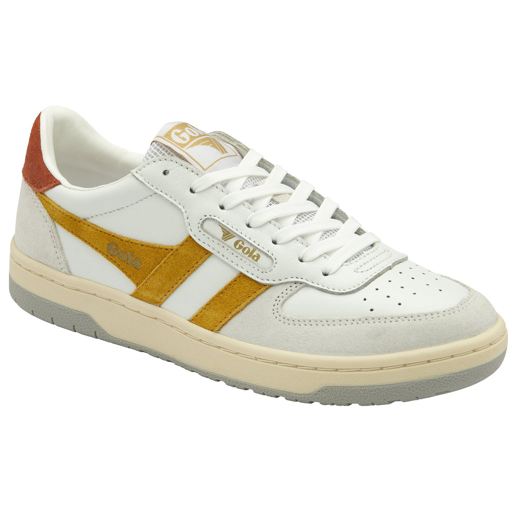 A white and gold Gola sneaker with an orange heel accent is displayed at a slight angle.