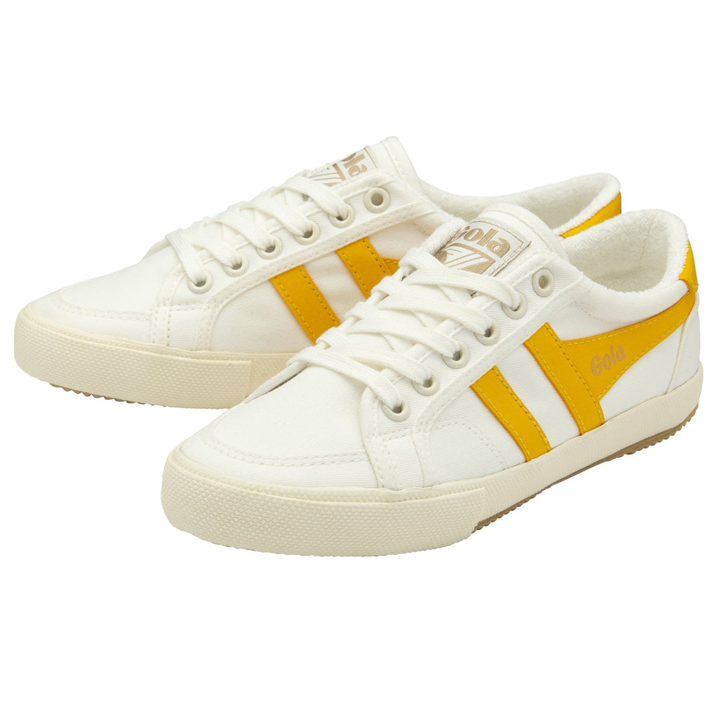 A pair of white Gola sneakers with two yellow stripes on the side.