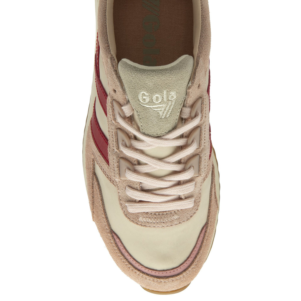 The top-down view of a single pale pink sneaker with red stripes and pink laces.