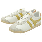 A pair of white Gola sneakers with gold stripes and beige soles, viewed from an angle.