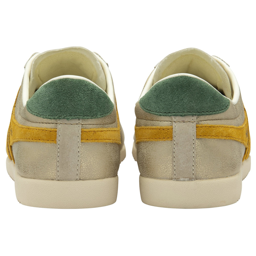 A back view of the heels of two women's trainers, in gold with green heel collars.