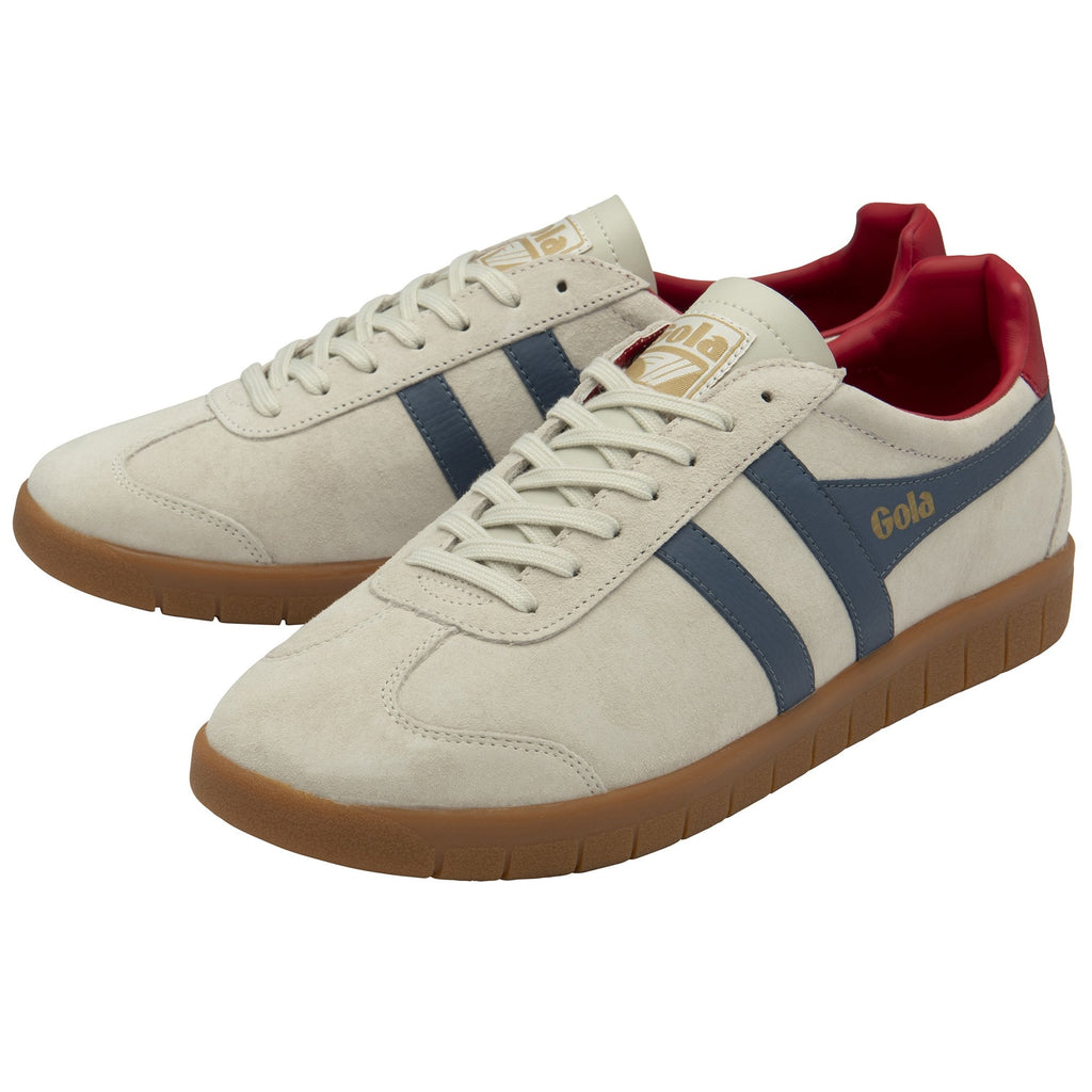 A pair of beige Gola trainers with blue stripes and red heels.