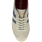 A top-down view of a beige Gola trainer with blue stripes.