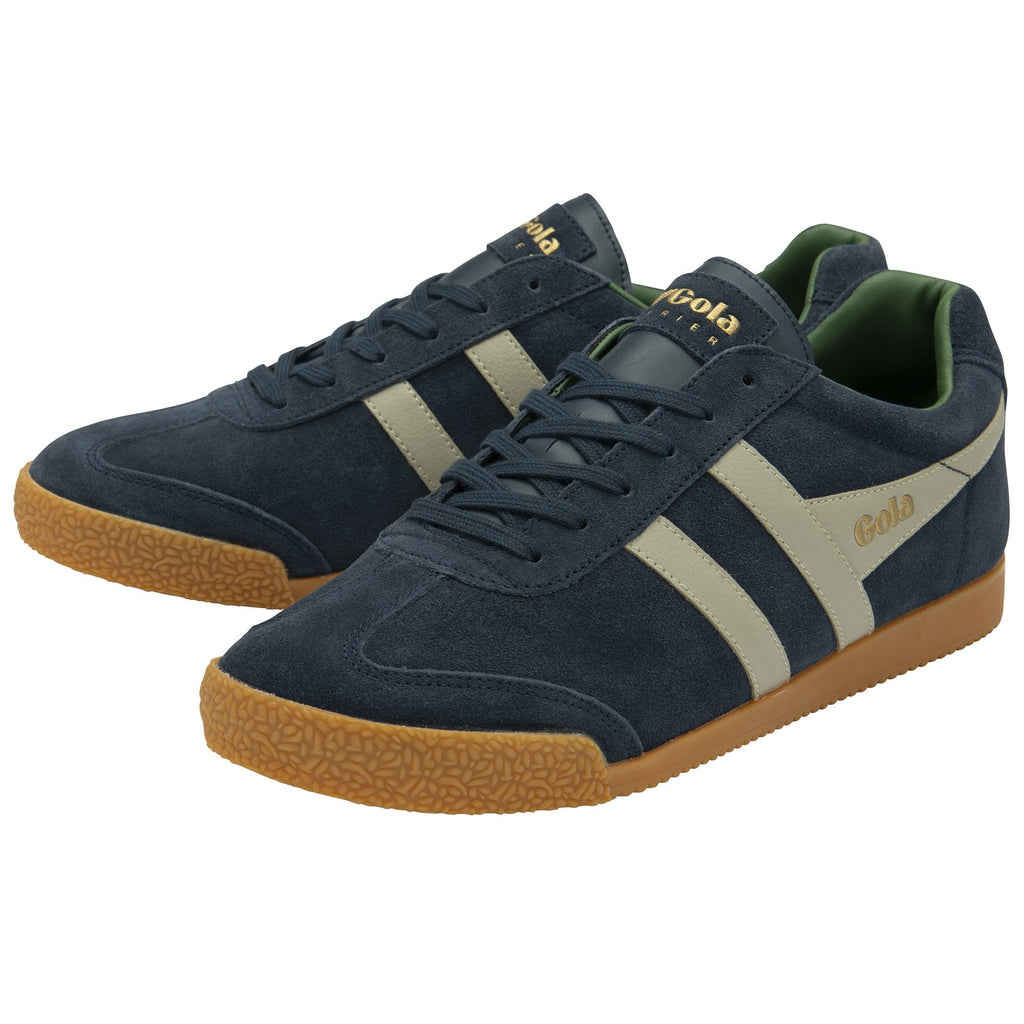 A pair of Gola Daytona trainers in navy blue with cream stripes from a slight angle.