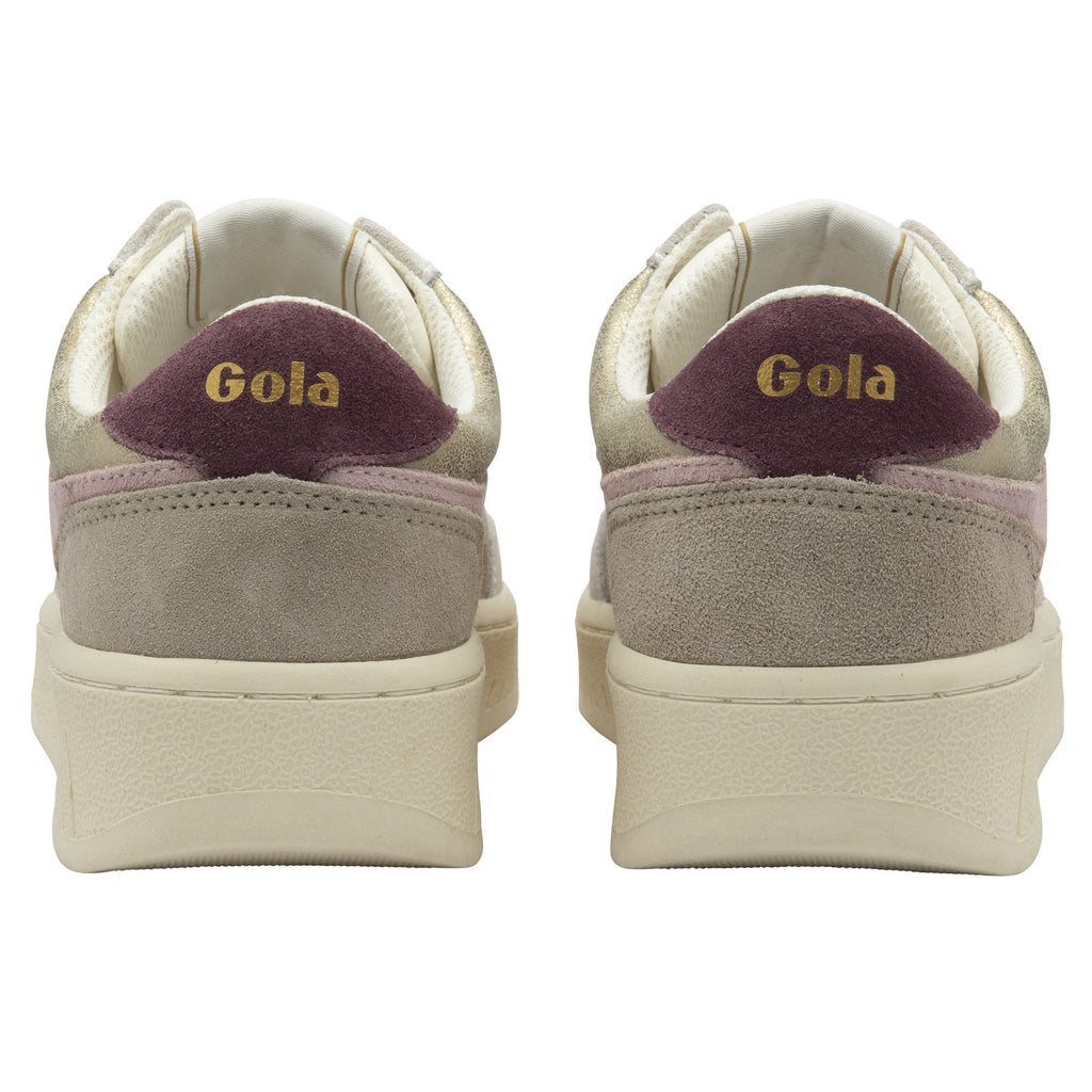 The backs of two Gola low-top sneakers in gold, white, and pink.