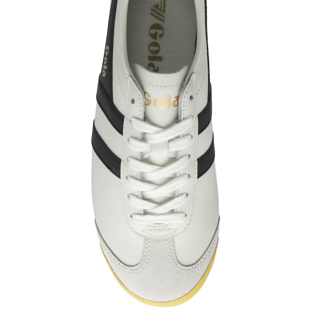 An overhead view of a white Gola sneaker with black stripes and white laces.