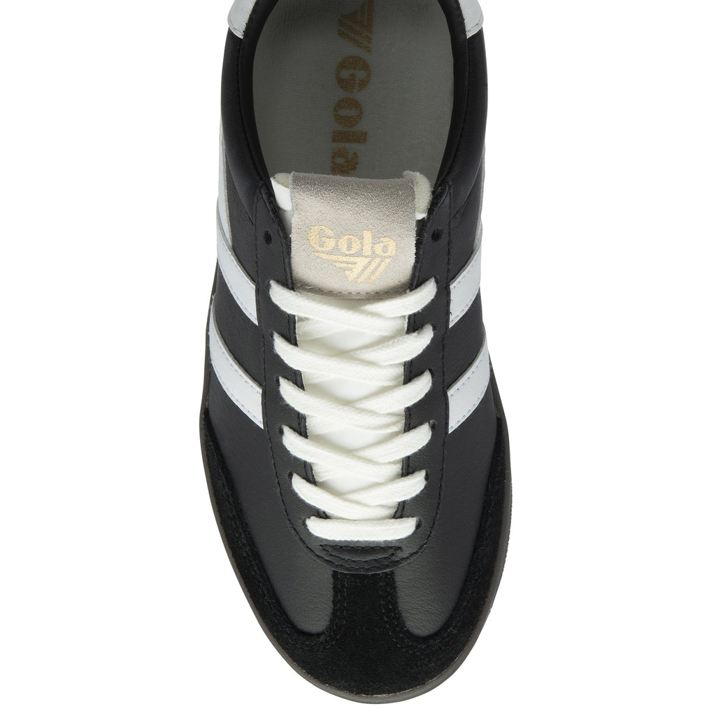 A top-down view of a single black and white Gola trainer with cream laces.