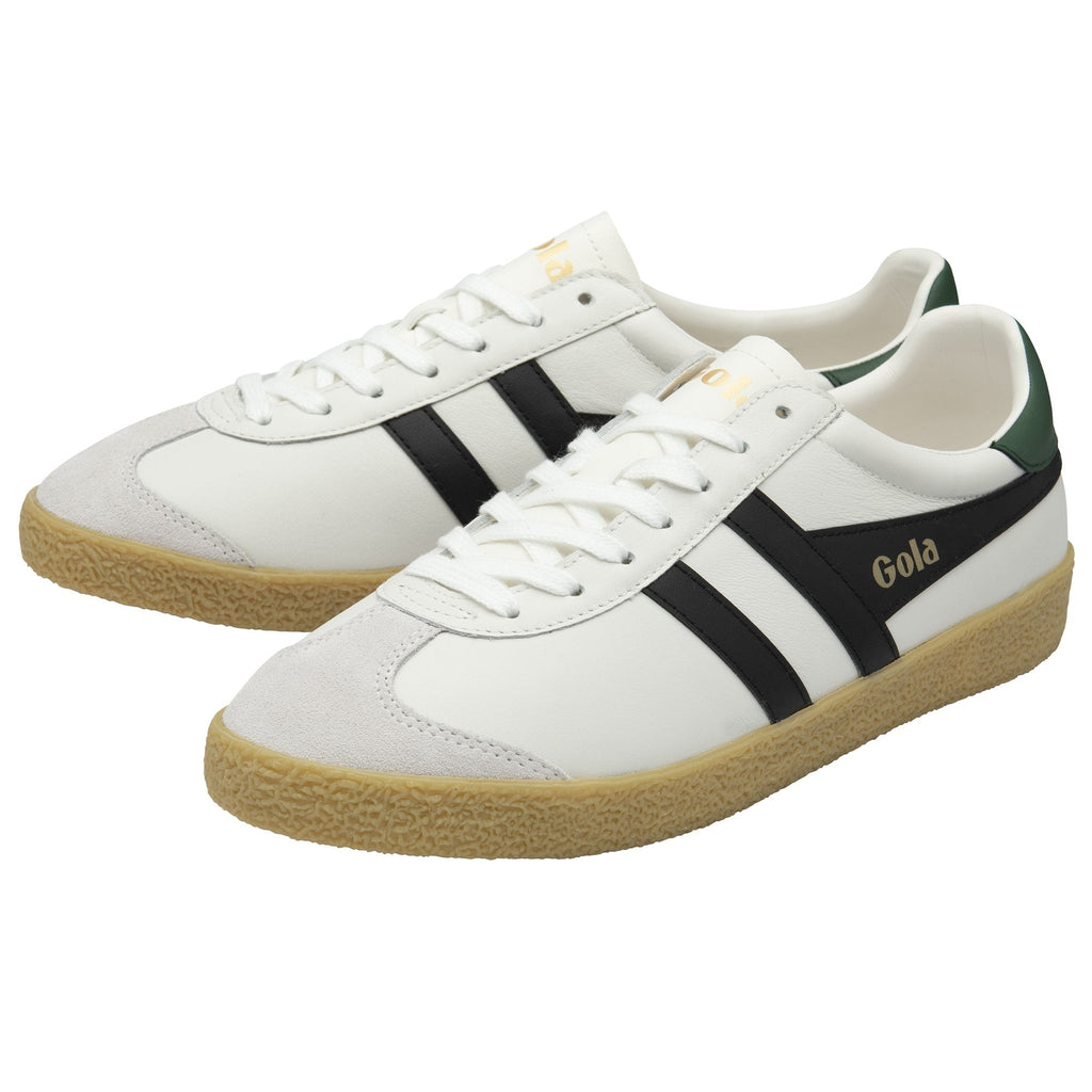 A pair of white and black Gola sneakers with green heel accents and brown soles.