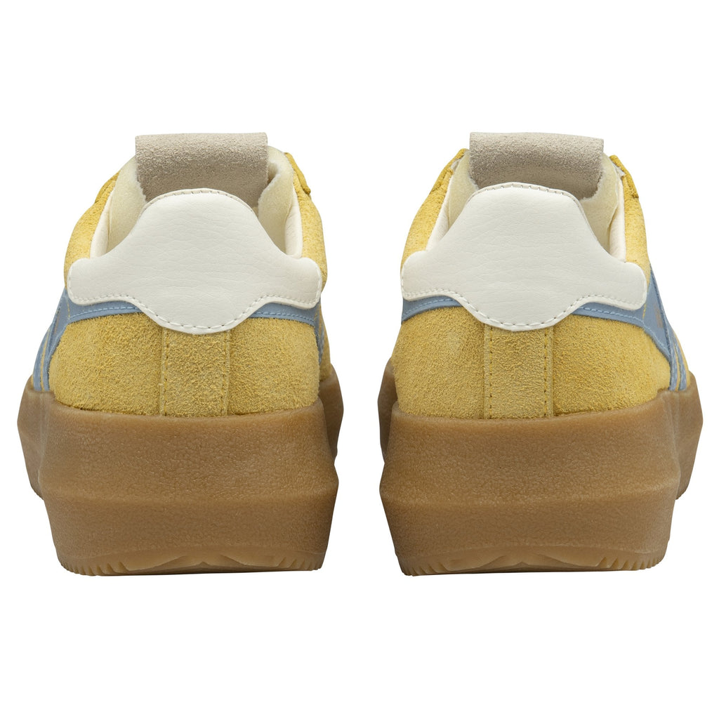 The back view of a pair of mustard yellow Gola sneakers with gum soles.