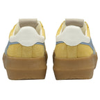 The back view of a pair of mustard yellow Gola sneakers with gum soles.