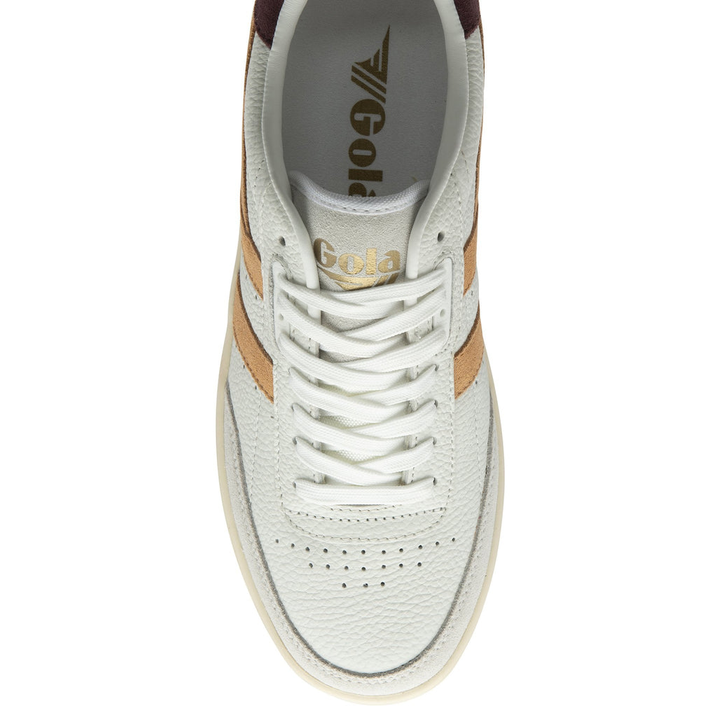 Top-down view of a white sneaker with tan stripes and white laces.