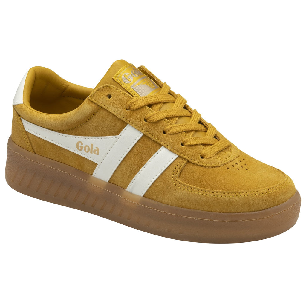 A mustard yellow Gola sneaker with white stripes and a brown sole, angled on a white background.