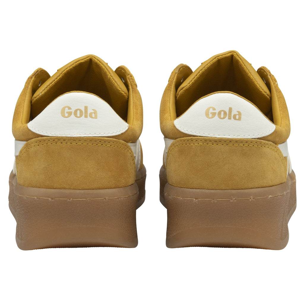 The back view of a pair of mustard yellow Gola sneakers with white heel accents and brown soles.