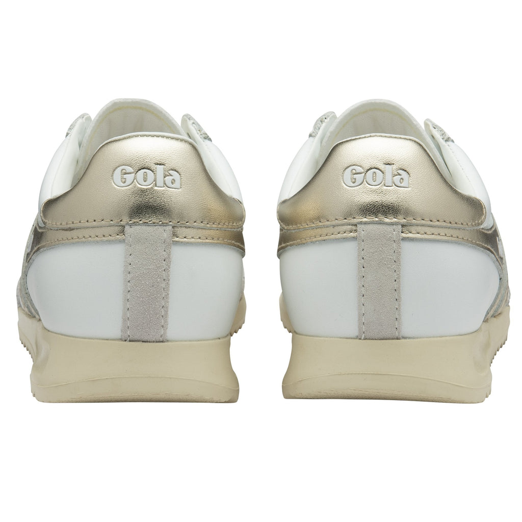 Back view of a pair of white and gold Gola sneakers.