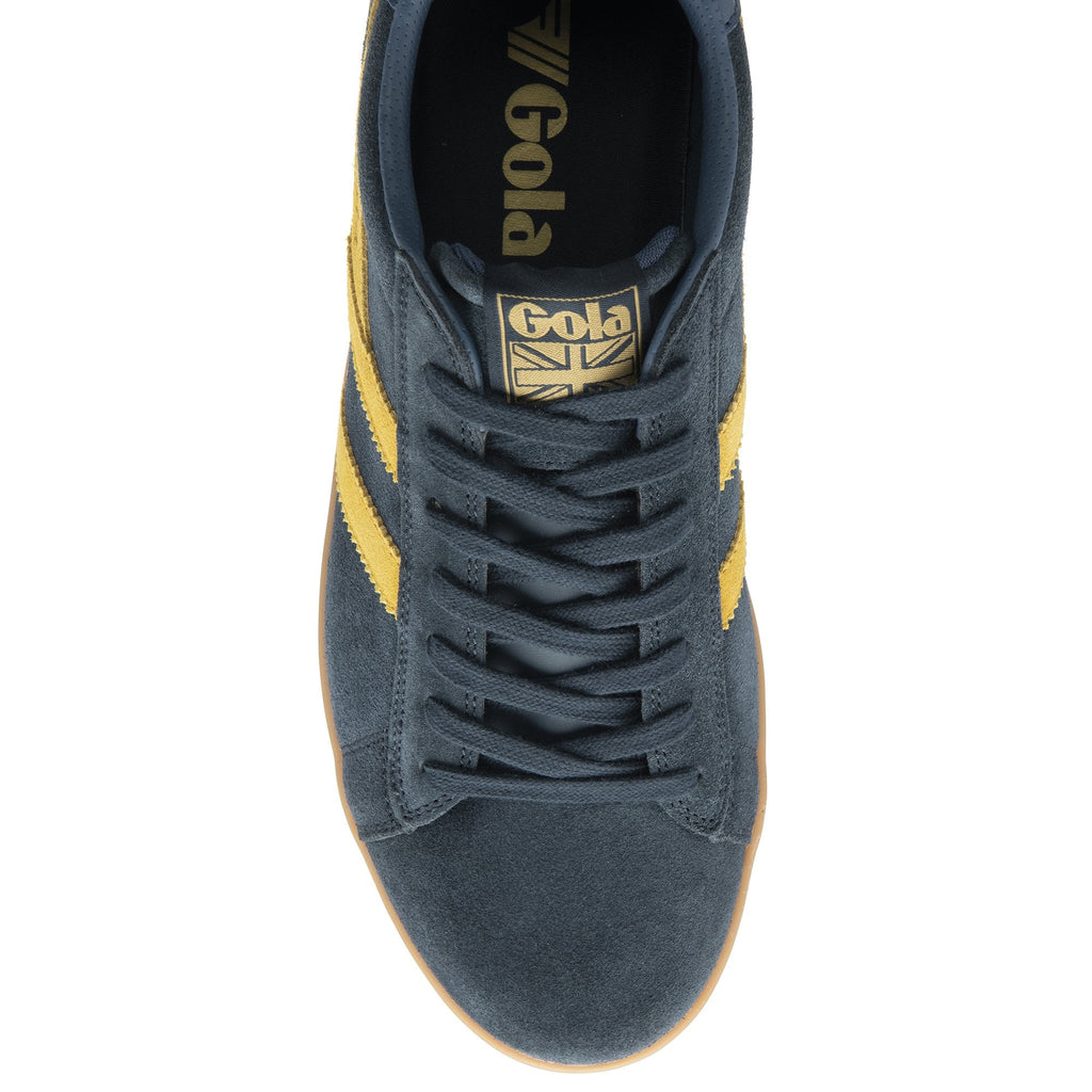 An overhead view of a dark blue suede Gola trainer with yellow stripes and a gum sole.