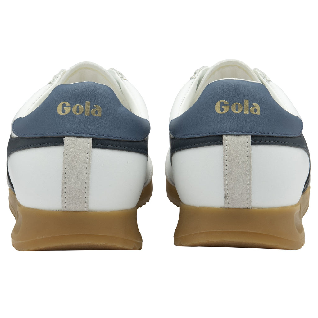 A pair of white and navy Gola sneakers with gum soles shown from the back.