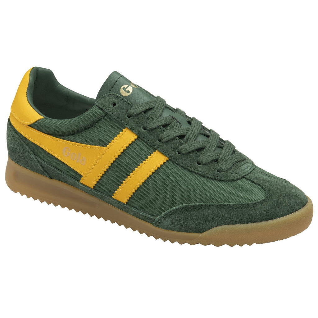 A close-up of a green Gola trainer with yellow stripes and a brown sole.