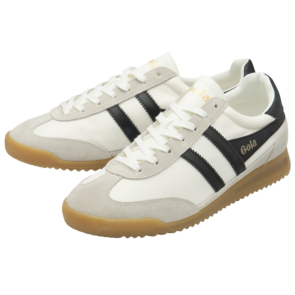 A pair of white Gola Harrier Trainers with black stripes and gum soles.