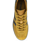 Overhead view of a single Gola Harrier shoe in mustard yellow suede with navy blue stripes and laces