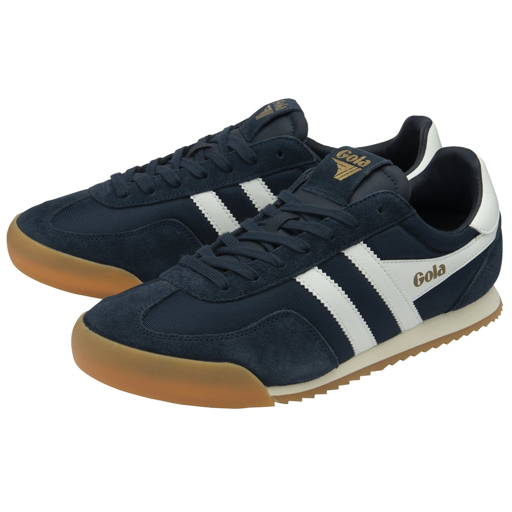 A pair of navy blue Gola trainers with white stripes and gum soles, viewed from an angle.