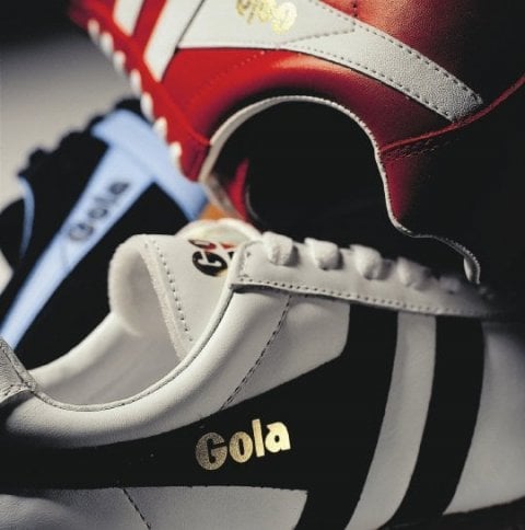 Three Gola sneakers in white, black, and red with white stripes and gold logos.