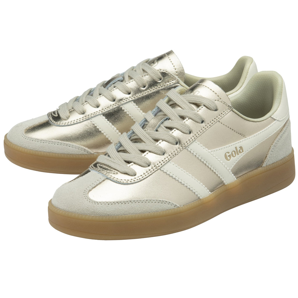 A pair of gold Gola sneakers with white stripes and brown soles, one slightly behind the other.