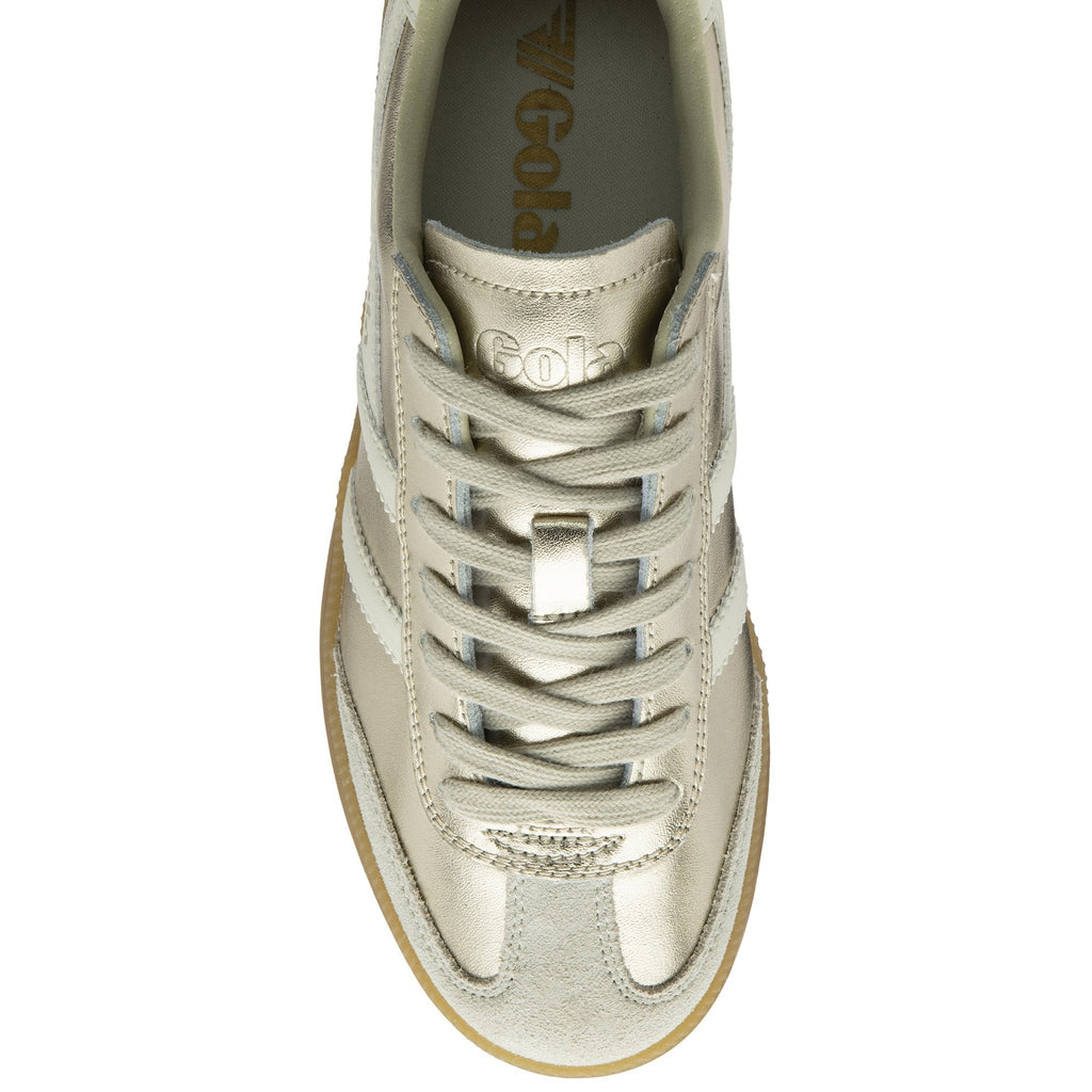 Top-down view of a shiny gold Gola sneaker with white stripes and matching laces.